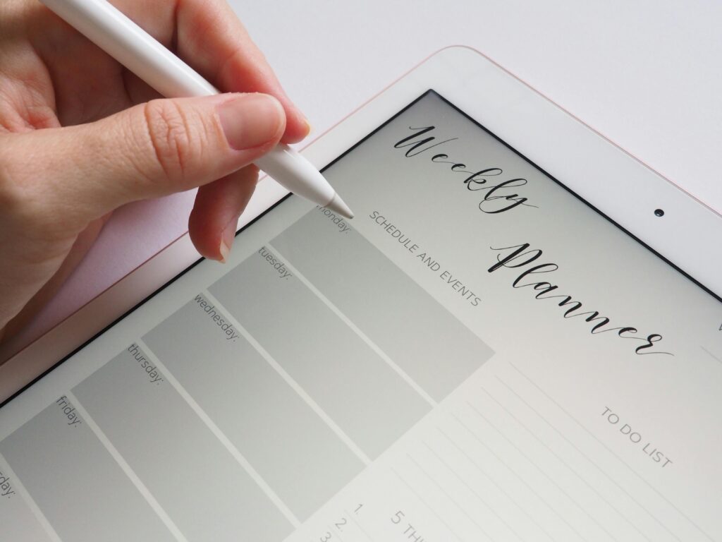 pexels-photo-768472-768472 A stylus writing in a digital weekly planner on a tablet screen, ideal for organization.